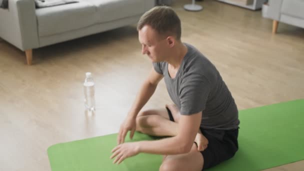 Man under individuell träning hemma avslappnande muskler och omsorg om hälsa — Stockvideo