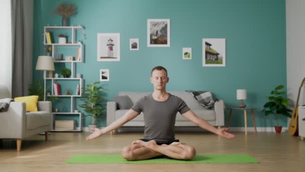 Man gör yoga hemma på morgonen i sitt vardagsrum — Stockvideo