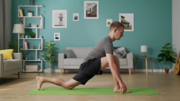 Genç adam sabah oturma odasında yoga yapıyor. — Stok video