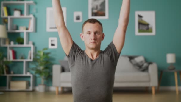Genç adam sabah oturma odasında yoga yapıyor. — Stok video