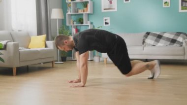 Oturma odasında egzersiz yapan genç adam