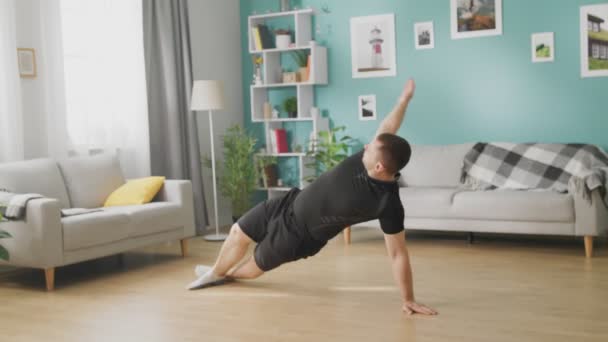 Jeune homme faisant des exercices dans son salon — Video