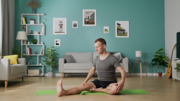 Jeune homme faisant du Yoga à la maison — Video