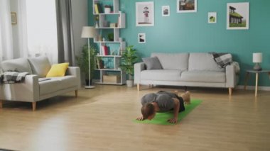 Evde yoga yapan genç adam.