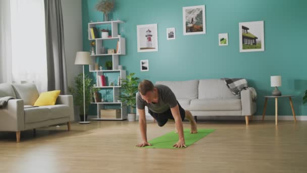 Młody człowiek uprawia jogę w domu — Wideo stockowe