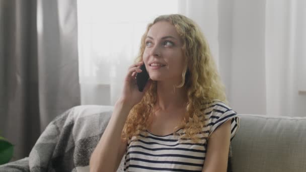 Ragazza che parla su un telefono cellulare a casa sul divano — Video Stock