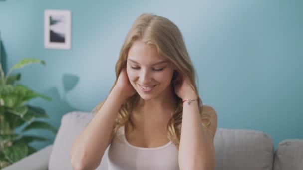 Portrait of happy young lady looking at camera and smiling in cozy living room — Stock Video