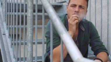 Yangın çıkışında sigara içen adam