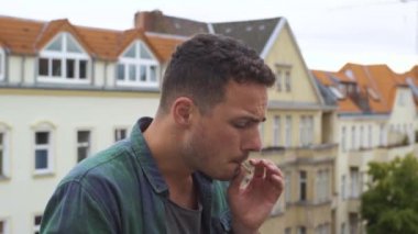 Şehirde merdivenlerde ot içen adam