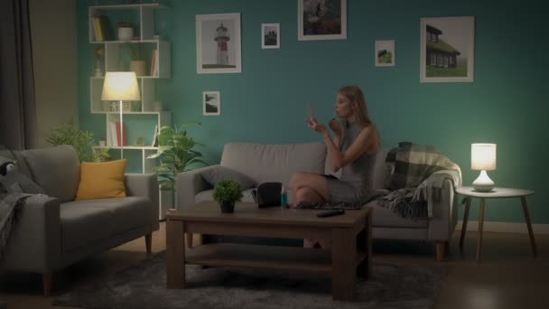 Ung kvinna gör make-up hemma på en soffa innan en fest — Stockvideo