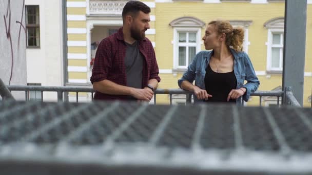 Junges Paar plaudert lustig auf der Treppe in der Stadt — Stockvideo