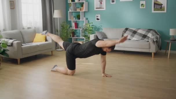 Joven está haciendo ejercicios en el piso de apartamento moderno — Vídeos de Stock