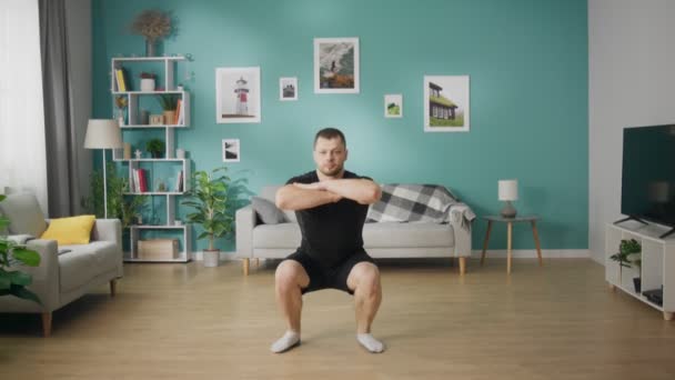 Νέος άνθρωπος κάνει ασκήσεις στο πάτωμα του μοντέρνου διαμερίσματος — Αρχείο Βίντεο