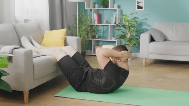 Jeune homme fait des exercices sur le sol de l'appartement moderne — Video