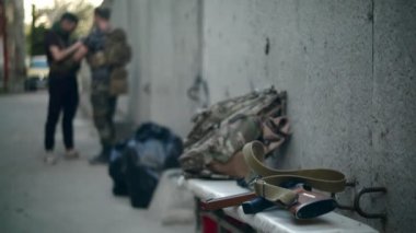Askerler sanayi bölgesinin arka planında konuşuyorlar.