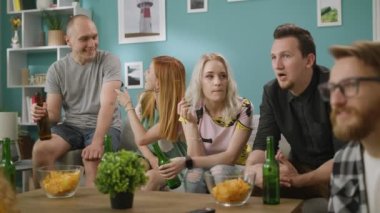 TV Izlerken arkadaş oturma odası grubu, ve atıştırmalıklar Ile bira Içecekler