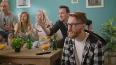 Televizyonda bir maç izlerken bir genç adamın takımını kazanmak için reaksiyon