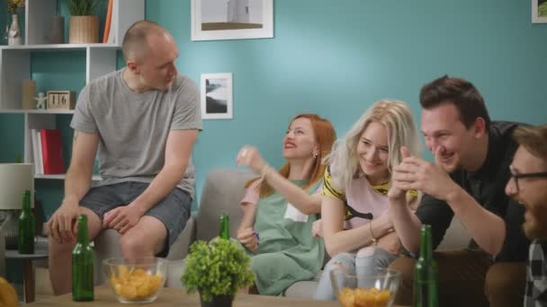 A group of friends watching a strange show on TV. — Stock Video