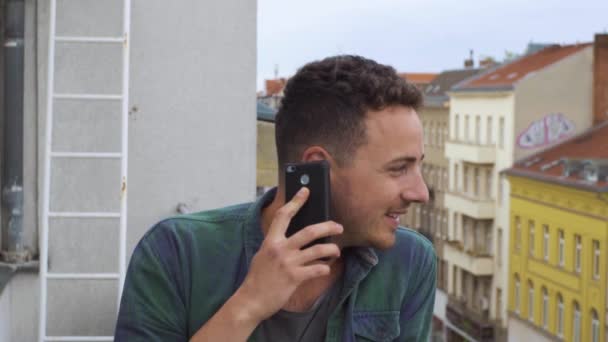 Ο τύπος με το τηλέφωνο στο μπαλκόνι της πόλης. — Αρχείο Βίντεο