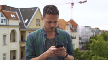 Büyük bir şehirde balkonda sms yazan adam