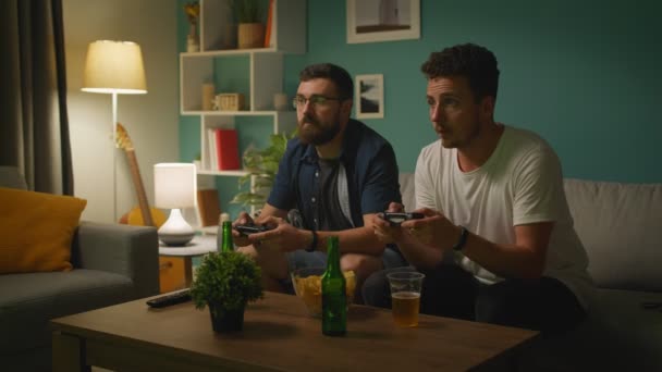 Amis masculins jouant sur une console de jeux ensemble — Video