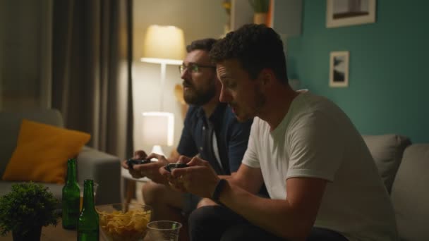 Manliga bröder som spelar på en spelkonsol tillsammans — Stockvideo
