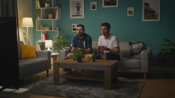 Amigos varones jugando juntos en una consola de juegos — Vídeos de Stock