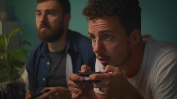 Amigos varones jugando juntos en una consola de juegos — Vídeo de stock