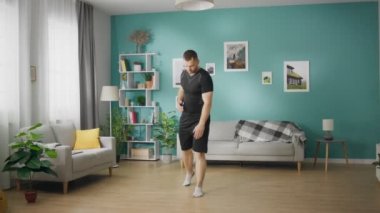 Öğleden sonra oturma odasında jimnastik yapan genç bir adam