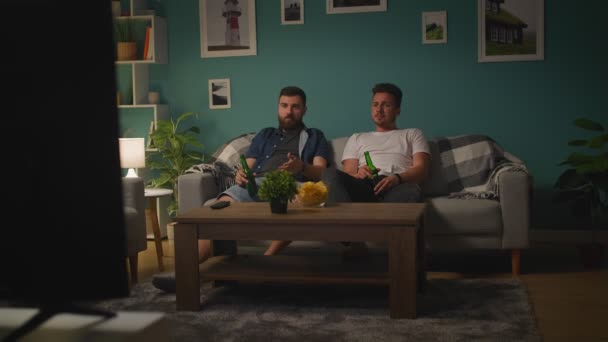 Junge Männer reden und regen sich auf, während sie Sportspiele im Fernsehen sehen — Stockvideo