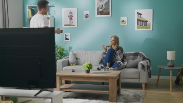 Mladý muž přivede svou přítelkyni kávu do útulného obývacího pokoje. — Stock video