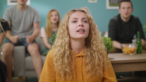 The reaction of a young woman to win their team while watching a match on TV — Stock Video