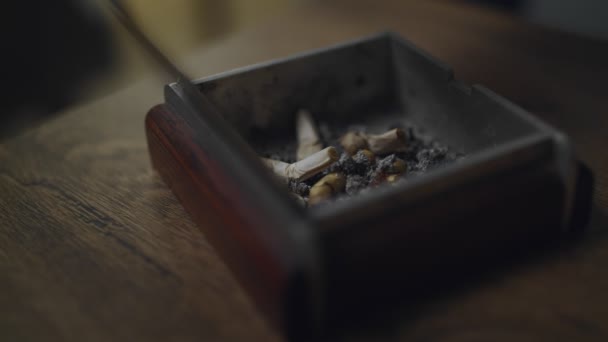 Felülnézet szög kézzel kidugta a dohányzás cigaretta egy hamutartó — Stock videók