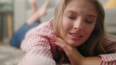 Genç kız, oturma odasında yerde yatan video sohbet tarafından iletişim kurar