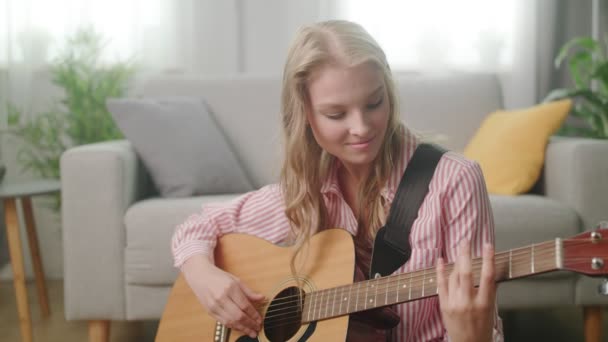 Mooie vrouw gitaar spelen in zijn woonkamer — Stockvideo