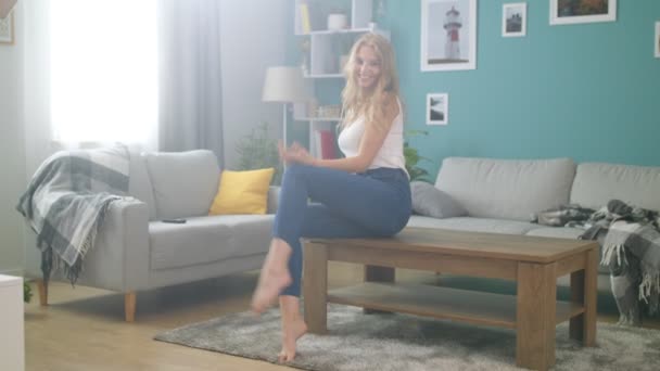 Kamera bakarak mutlu genç Bayan portre ve rahat oturma odasında gülümsüyor — Stok video