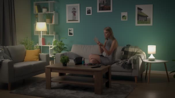 若い女性はパーティーの前にソファで家でメイクアップをする — ストック動画