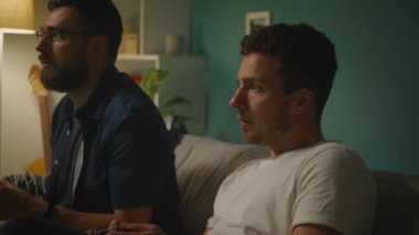 Oturma odasında Iki kardeşler bir kanepede oturan video oyunu oynuyor