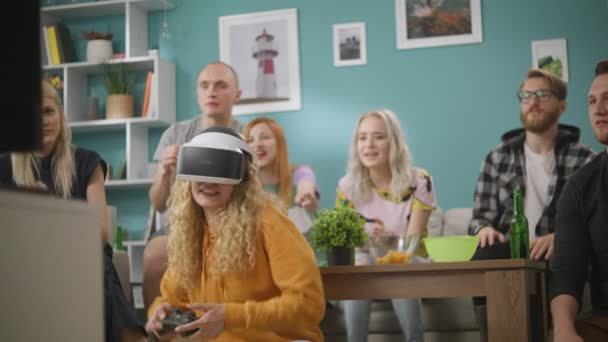 Frau im Virtual-Reality-Helm spielt zu Hause mit ihren Freunden Spiele — Stockvideo