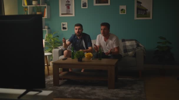 Dos hombres viendo la competición de fútbol en pantalla grande animando mejor equipo de fútbol — Vídeos de Stock