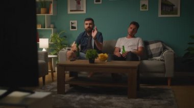 İki genç adam TV ve öfke oyun tartışmak ve takım kaybetme oyun izliyor
