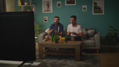 Oturma odasında Iki kardeşler bir kanepede oturan video oyunu oynuyor