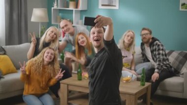 Birlikte kanepede oturan ve akıllı telefon ile selfie alarak arkadaş grubu
