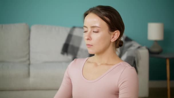 Vrouw mediteert na het beoefenen van yoga in haar woonkamer. — Stockvideo