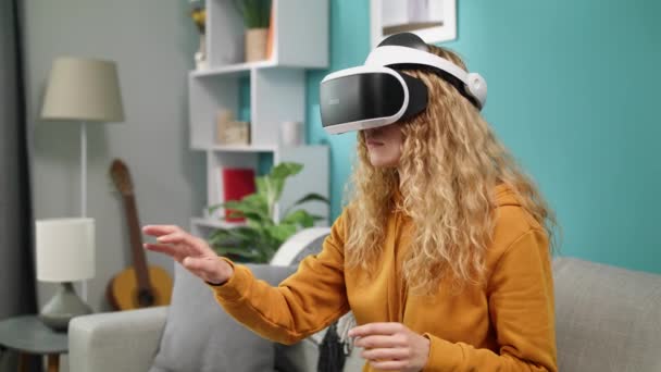 Mulher nos óculos VR com fone de ouvido VR no quarto em casa — Vídeo de Stock