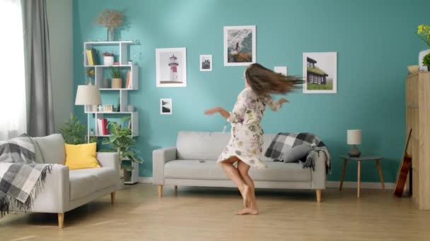 Feliz hermosa mujer bailando en su sala de estar — Vídeos de Stock