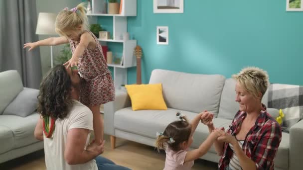 Hija de pie equilibrio en las manos de los papás — Vídeos de Stock