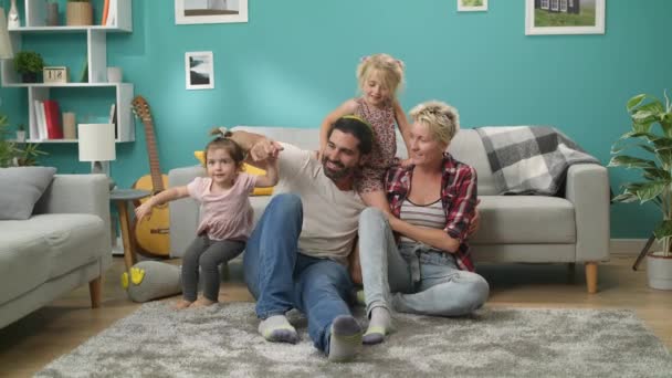 Retrato de una familia alegre en casa en el salón — Vídeo de stock