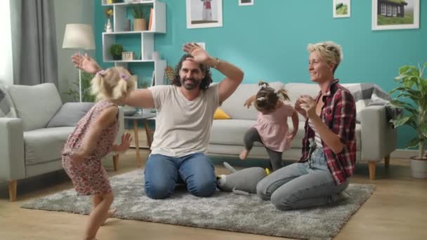 Αξιολάτρευτο μικρό κορίτσι χορεύει με τον μπαμπά και τη μαμά στο σπίτι — Αρχείο Βίντεο