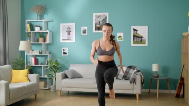 Belle femme mince fait des exercices cardio matinaux en cours d'exécution sur place dans la chambre — Video